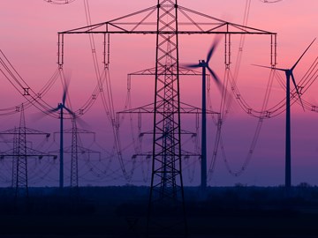 Stromnetz mit Windkraftanlagen im Hintergrund Stromnetz mit Windkraftanlagen im Hintergrund