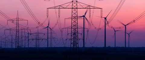 Stromnetz mit Windkraftanlagen im Hintergrund Stromnetz mit Windkraftanlagen im Hintergrund