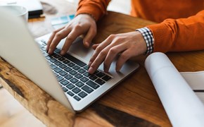 Hände auf einer Laptop-Tastatur Hände auf einer Laptop-Tastatur