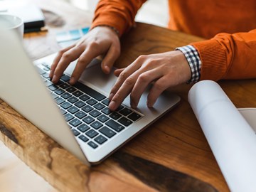 Hände auf einer Laptop-Tastatur Hände auf einer Laptop-Tastatur