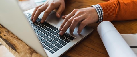 Hände auf einer Laptop-Tastatur Hände auf einer Laptop-Tastatur