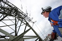 Mann blauer Overoll + Helm vor Hochspannungsmast Mann blauer Overoll + Helm vor Hochspannungsmast