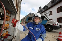 enviaM-Mitarbeiter an Verteilerkasten vor Messwagen enviaM-Mitarbeiter an Verteilerkasten vor Messwagen