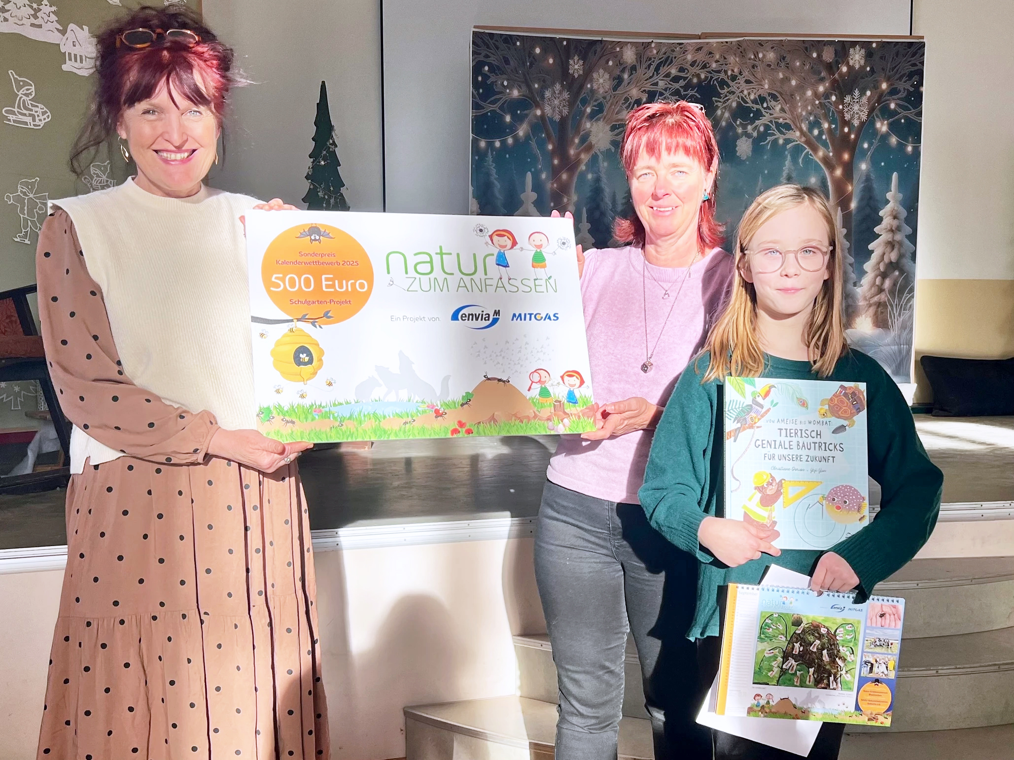 die Gewinnerin und ihre Lehrerin mit Geschenken und einem Spendenscheck