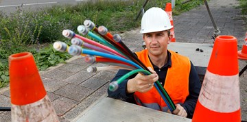 Mann verlegt Glasfaserkabel Mann verlegt Glasfaserkabel