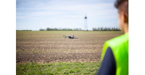 Kollege von MITNETZ STROM mit einer Drohne, die über ein Feld fliegt Kollege von MITNETZ STROM mit einer Drohne, die über ein Feld fliegt
