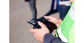 Kollege von MITNETZ STROM bei der Leitungsinspektion mit einer Drohnensteuerung in den Händen Kollege von MITNETZ STROM bei der Leitungsinspektion mit einer Drohnensteuerung in den Händen