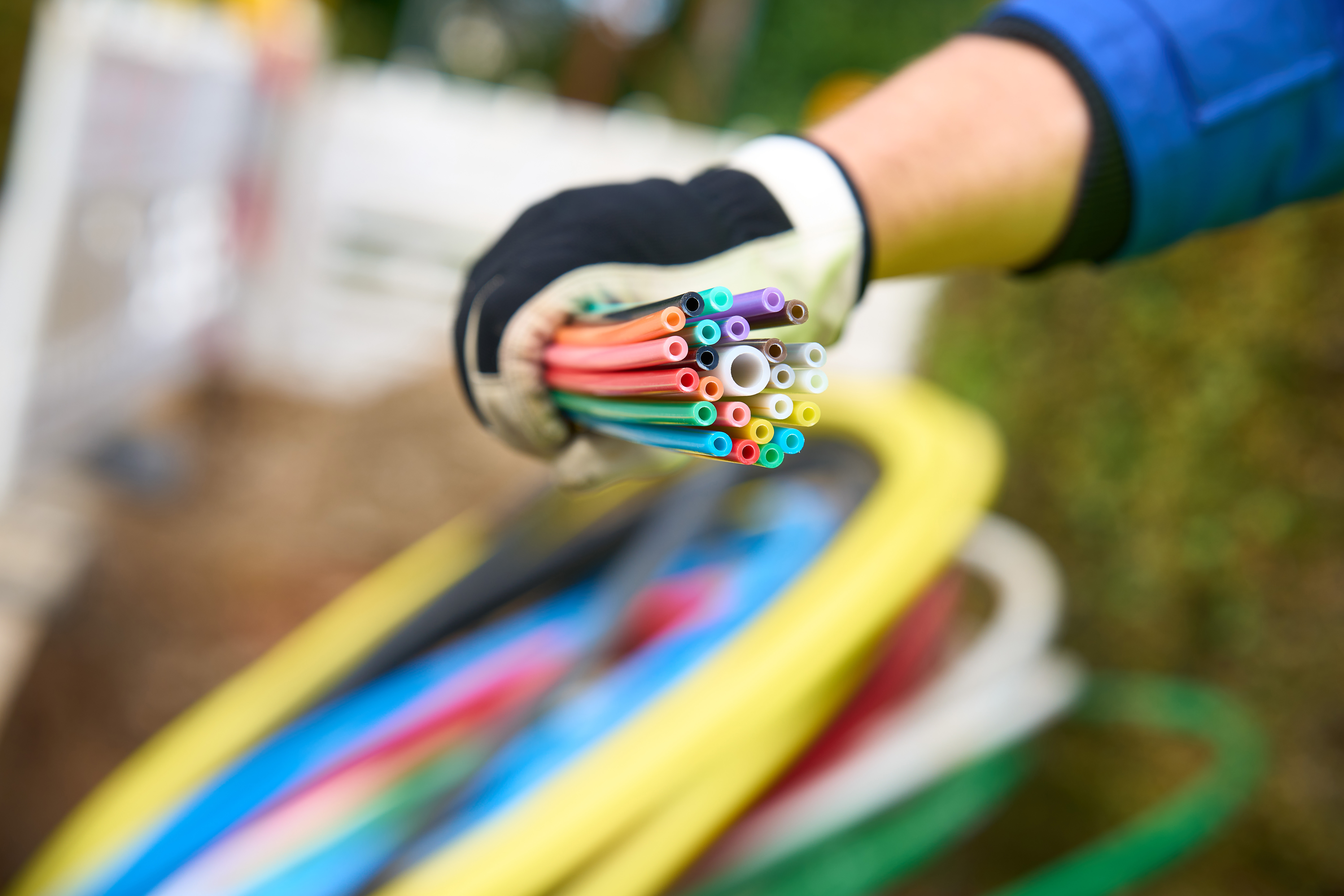 ein Mitarbeiter der envia TEL auf einer Baustelle mit einem Bündel Glasfaserkabel in der Hand