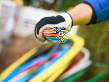 ein Mitarbeiter der envia TEL auf einer Baustelle mit einem Bündel Glasfaserkabel in der Hand ein Mitarbeiter der envia TEL auf einer Baustelle mit einem Bündel Glasfaserkabel in der Hand