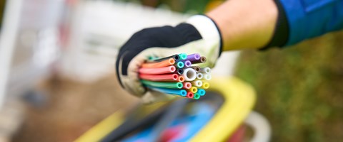 ein Mitarbeiter der envia TEL auf einer Baustelle mit einem Bündel Glasfaserkabel in der Hand ein Mitarbeiter der envia TEL auf einer Baustelle mit einem Bündel Glasfaserkabel in der Hand