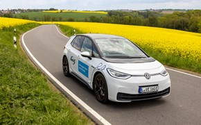E-Auto fährt durch Rapsfeld E-Auto fährt durch Rapsfeld