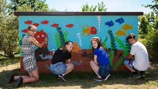 Graffiti-Präventionstag, 4 Jugendliche besprühen ein Verteilerhäuschen mit Aquarium-Motiv Graffiti-Präventionstag, 4 Jugendliche besprühen ein Verteilerhäuschen mit Aquarium-Motiv