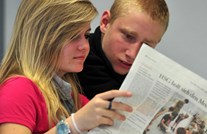Schülerin und Schüler lesen gemeinsam Zeitung Schülerin und Schüler lesen gemeinsam Zeitung