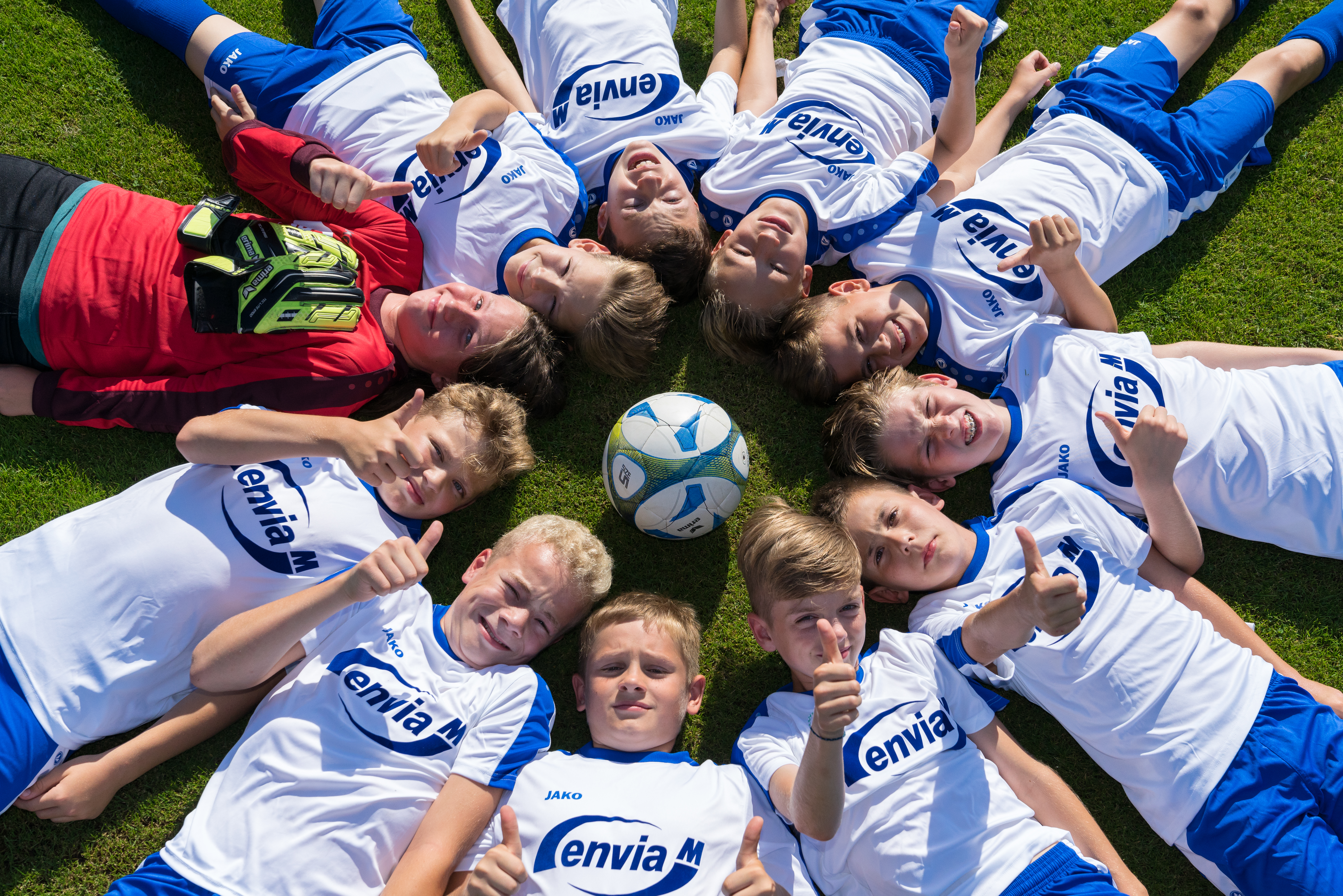 Junge Fußballspieler im enviaM-Trikot zeigen ihre Zustimmung