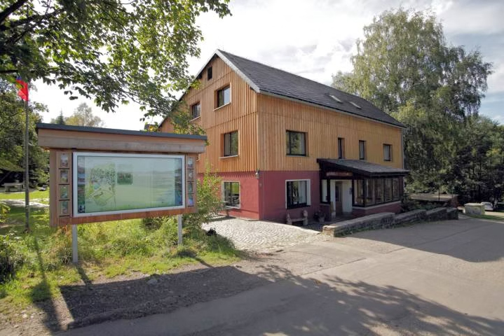 Naturschutzzentrum Erzgebirge mit einer Informationstafel im Vordergrund