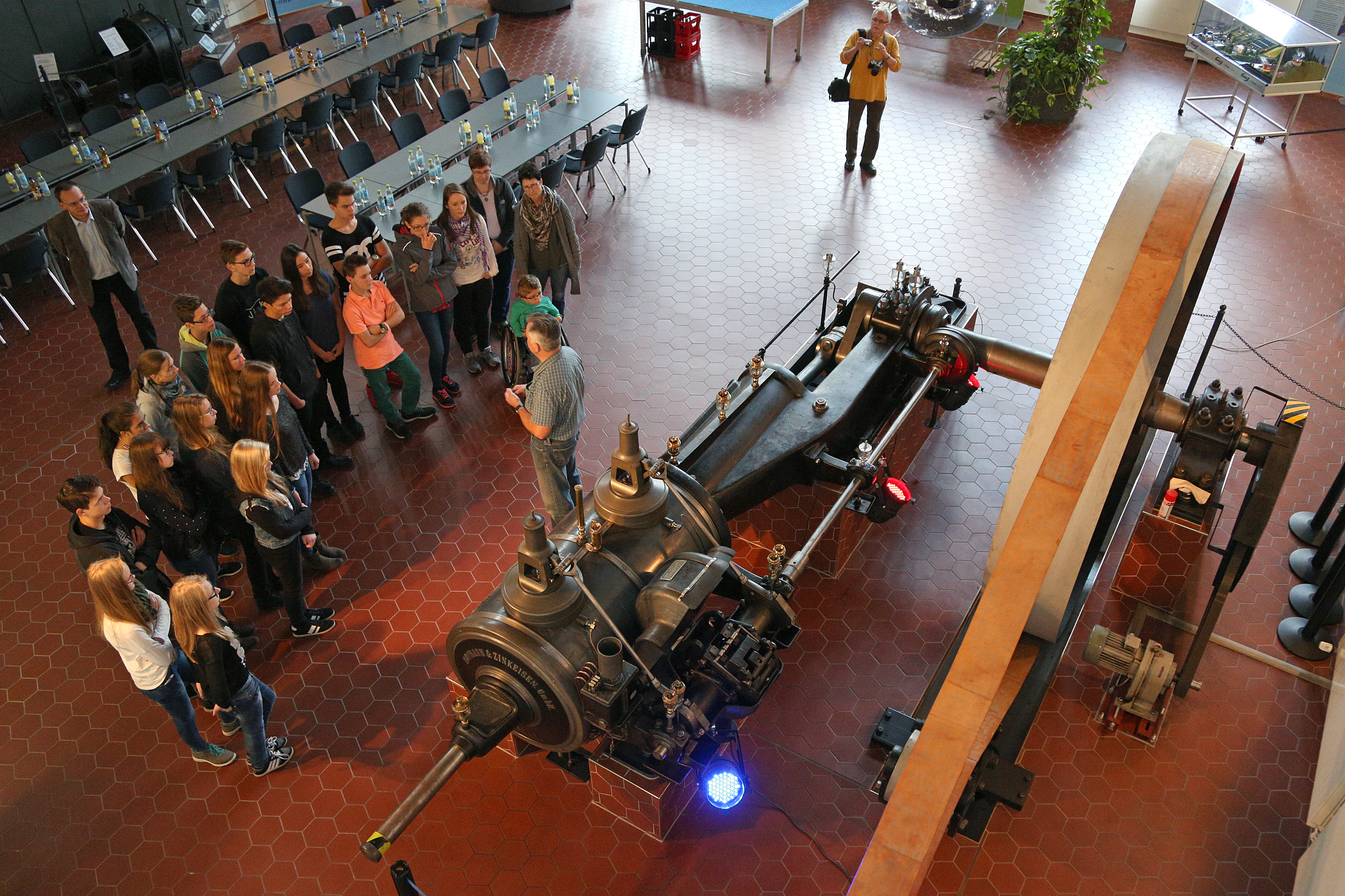 Schülergruppe besichtigt eine große historische Dampfmaschine