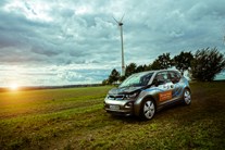 BMW i3 auf einer Wiese vor einem Windrad BMW i3 auf einer Wiese vor einem Windrad