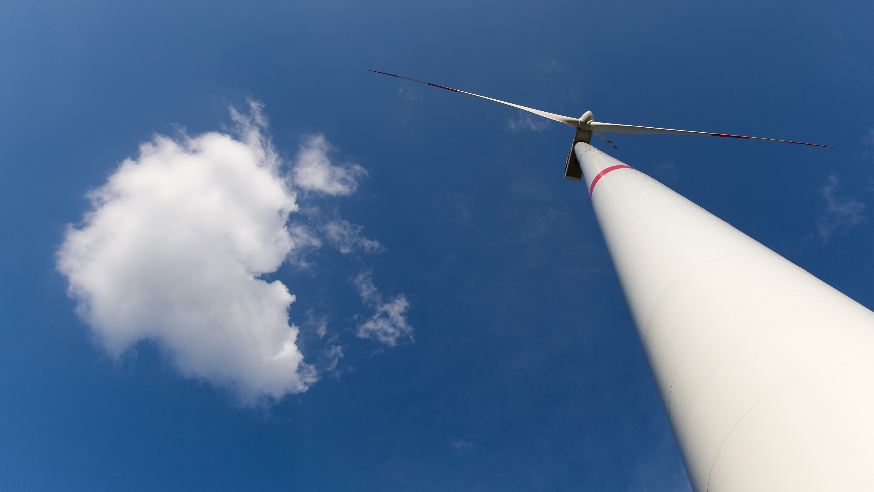 Windkraftanlage vor blauem Himmel mit Wolke im Windpark Briesensee