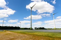 Distanzaufnahme Windkrafträder ragen in einen leicht bewölkten azurblauen Himmel Distanzaufnahme Windkrafträder ragen in einen leicht bewölkten azurblauen Himmel