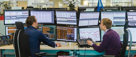 Energiehändler sitzen vor Monitoren Energiehändler sitzen vor Monitoren